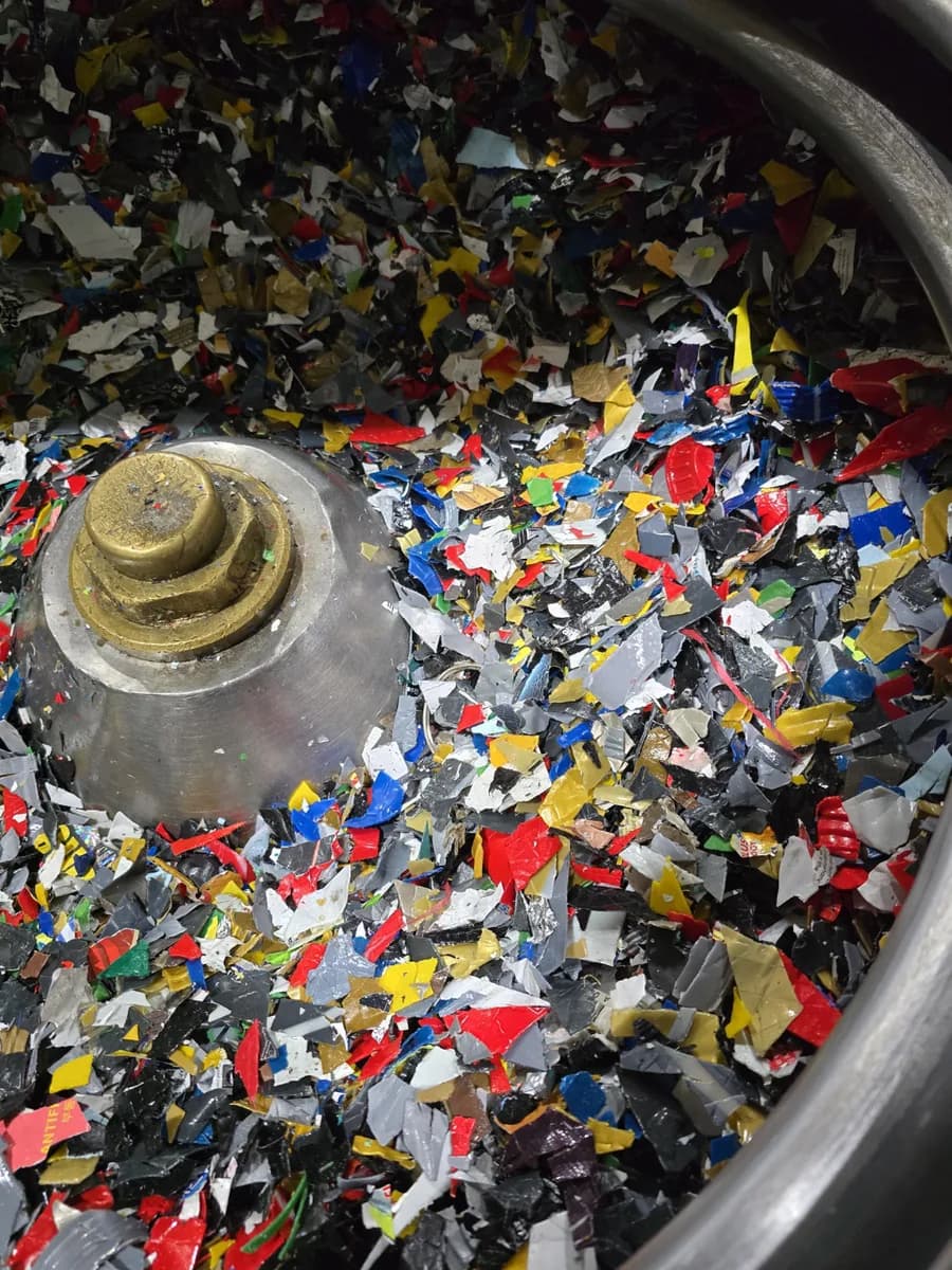 Mixed-colour recycled plastic flakes in a granulator